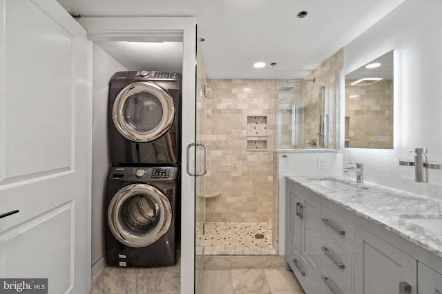 laundry area with light tile patterned flooring, stacked washer / dryer, and sink