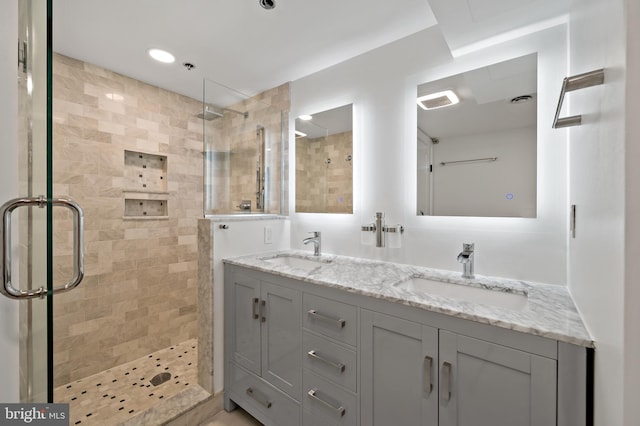 bathroom with walk in shower and dual vanity