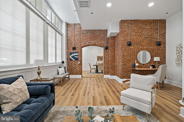 living room featuring light hardwood / wood-style floors and brick wall