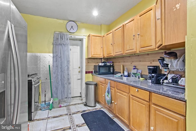 kitchen with appliances with stainless steel finishes, wooden walls, and sink