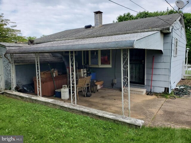 5602 Todd Ave, Baltimore, MD 21206 - back of house featuring roof with shingles, a patio, and a chimney