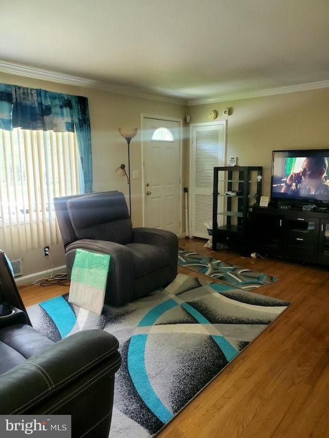 living room featuring wood-type flooring and ornamental molding