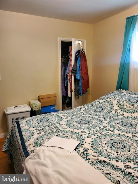 5602 Todd Ave, Baltimore, MD 21206 - bedroom featuring wood finished floors, a walk in closet, a closet, and baseboards