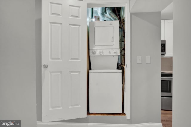 washroom featuring stacked washer / dryer