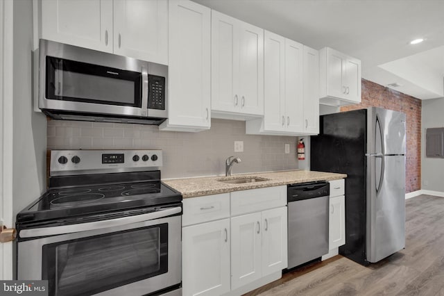 kitchen with white cabinetry, sink, light hardwood / wood-style flooring, and appliances with stainless steel finishes