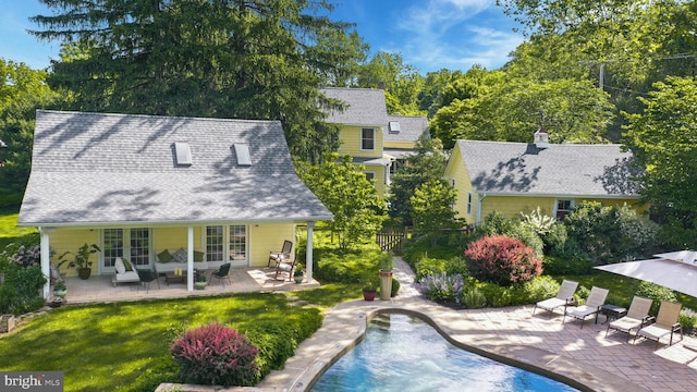 rear view of house featuring a yard and a patio