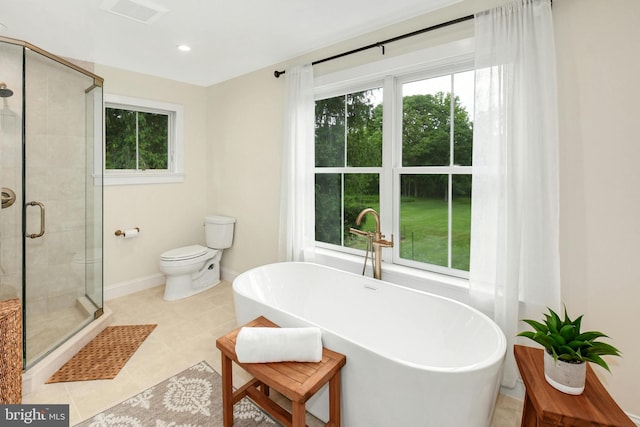 bathroom with tile patterned floors, toilet, and shower with separate bathtub