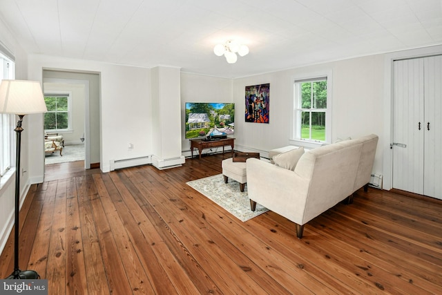 living room with ornamental molding, dark hardwood / wood-style flooring, a wealth of natural light, and a baseboard heating unit