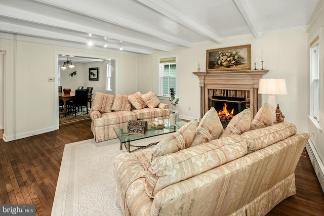 living room featuring beamed ceiling, dark hardwood / wood-style floors, a fireplace, and a baseboard heating unit