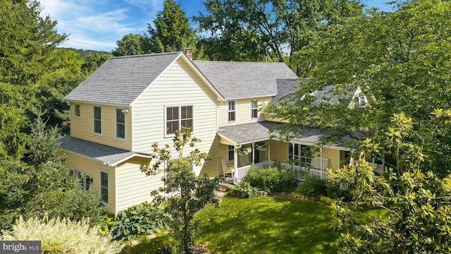 view of front of house with covered porch and a front lawn