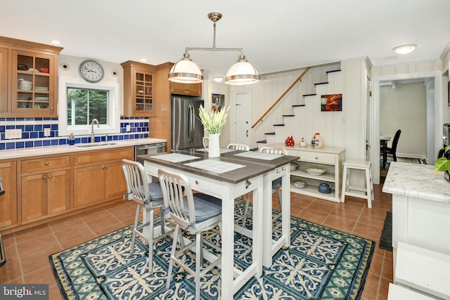 kitchen featuring pendant lighting, sink, stainless steel fridge, dark tile patterned floors, and tasteful backsplash