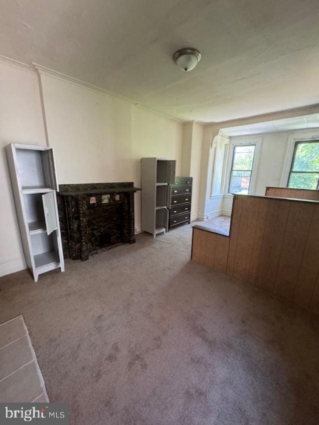 unfurnished bedroom with a fireplace and light carpet