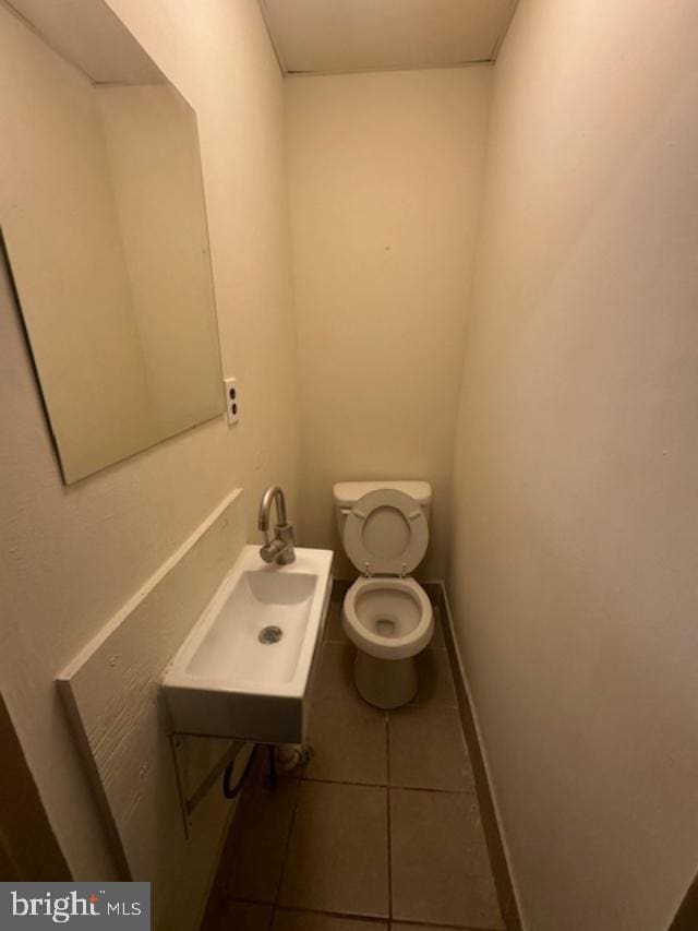 bathroom with tile patterned flooring, toilet, and sink