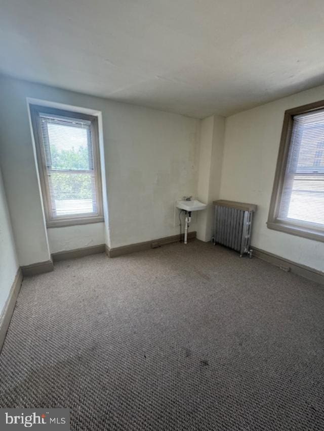 carpeted spare room with radiator heating unit