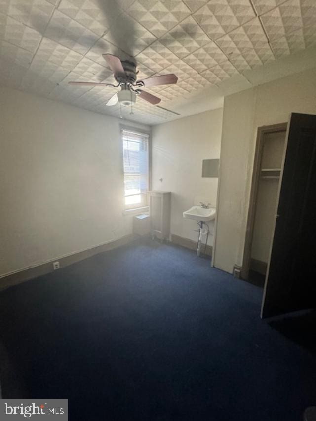 unfurnished bedroom featuring ceiling fan, a closet, and carpet