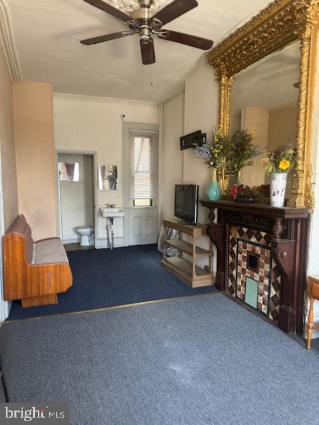 living room with carpet flooring, ceiling fan, and crown molding