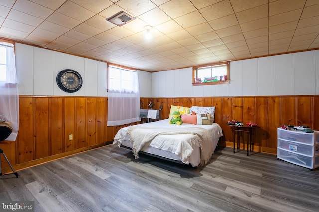 bedroom featuring wood-type flooring and wooden walls