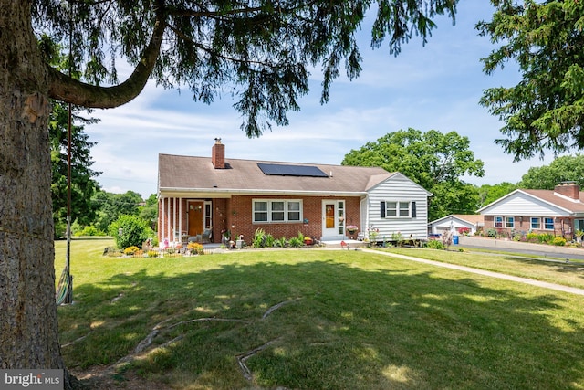 single story home featuring a front lawn and solar panels