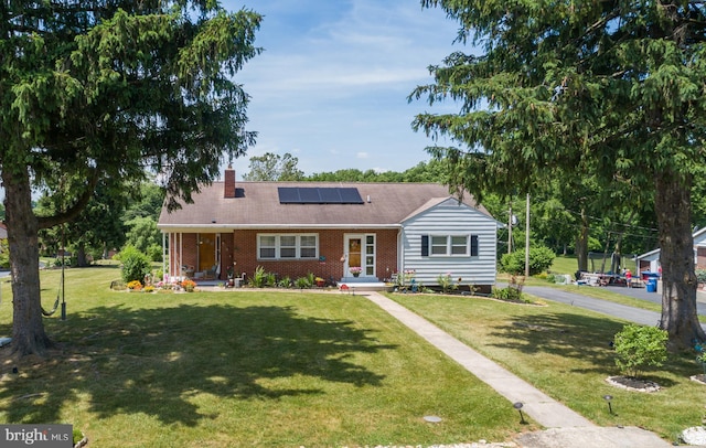 ranch-style house with solar panels and a front lawn