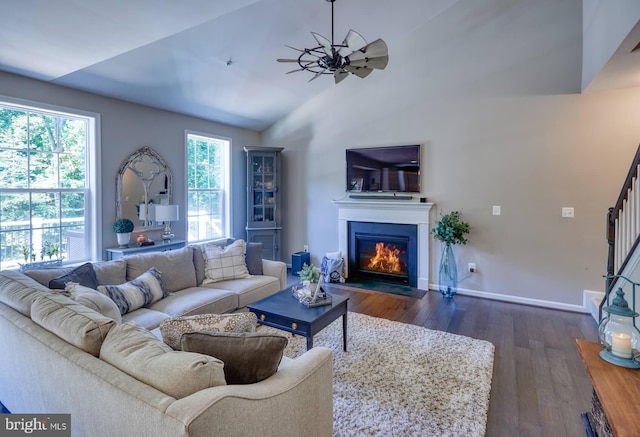 living room with dark hardwood / wood-style floors, vaulted ceiling, ceiling fan, and a healthy amount of sunlight