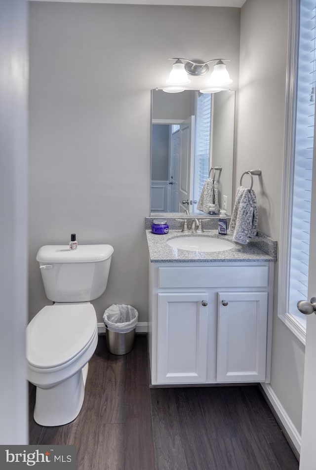 bathroom featuring wood-type flooring, vanity, and toilet