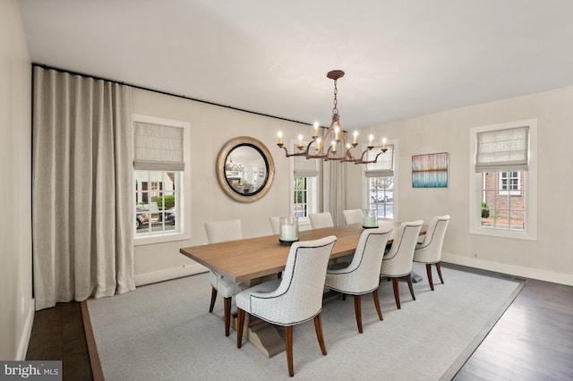 dining area with a notable chandelier and dark hardwood / wood-style floors