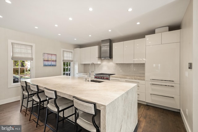 kitchen featuring a center island with sink, white cabinetry, a wealth of natural light, and dark hardwood / wood-style floors