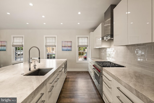 kitchen with dark hardwood / wood-style flooring, white cabinetry, range with two ovens, and sink