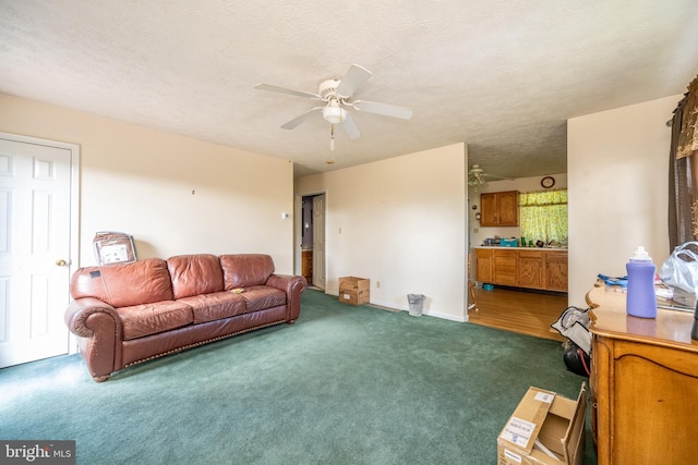 living room featuring dark colored carpet, ceiling fan, and a textured ceiling