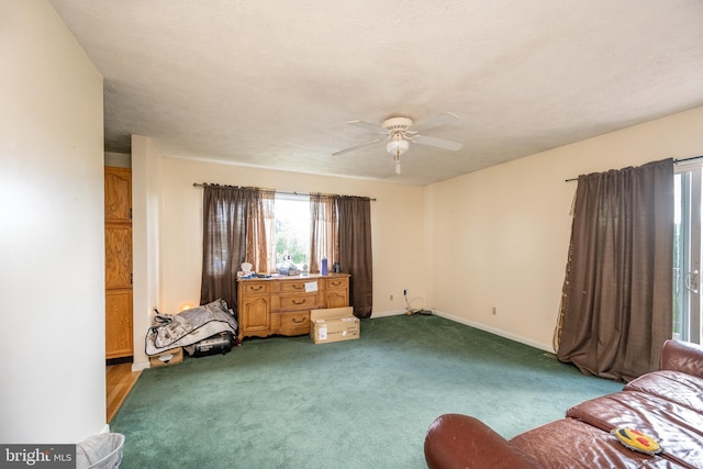 sitting room with ceiling fan, carpet floors, and a textured ceiling