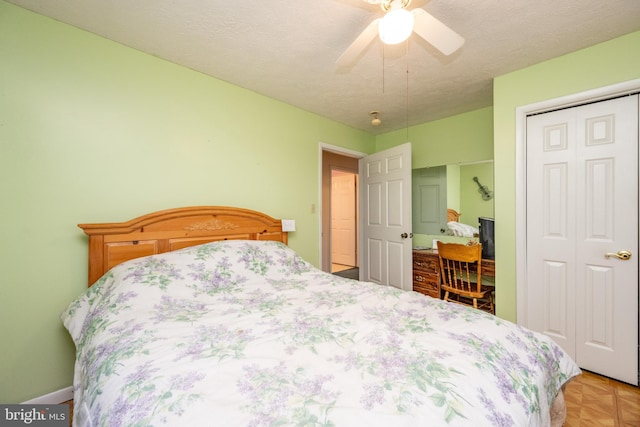 bedroom featuring ceiling fan, a closet, light parquet flooring, and a textured ceiling