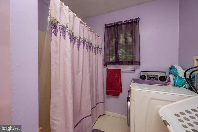 bathroom featuring a shower with shower curtain, a textured ceiling, and independent washer and dryer