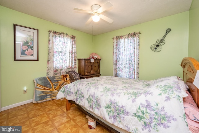 bedroom featuring parquet floors, multiple windows, and ceiling fan