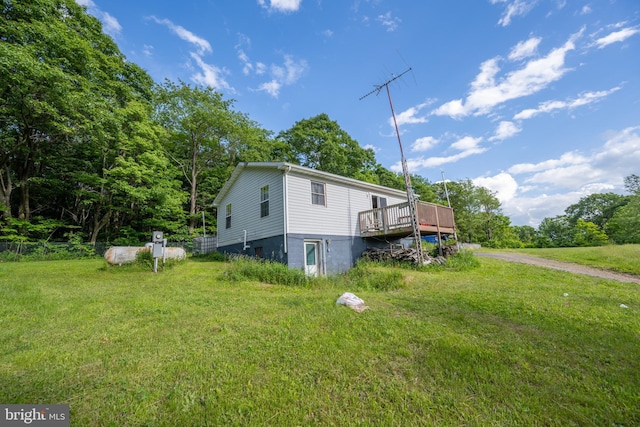 view of side of property featuring a deck and a yard