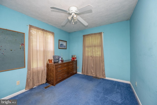 carpeted bedroom with ceiling fan and a textured ceiling