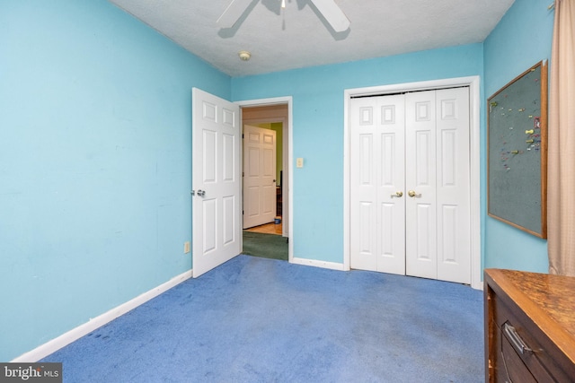 unfurnished bedroom featuring dark colored carpet, ceiling fan, and a closet