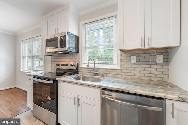 kitchen featuring plenty of natural light, white cabinetry, sink, and appliances with stainless steel finishes