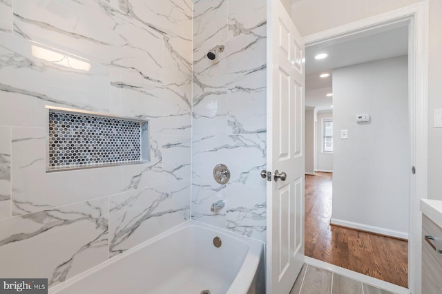 bathroom with vanity, hardwood / wood-style floors, and tiled shower / bath combo