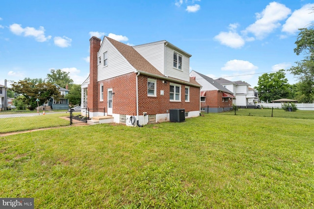 view of home's exterior with cooling unit and a yard