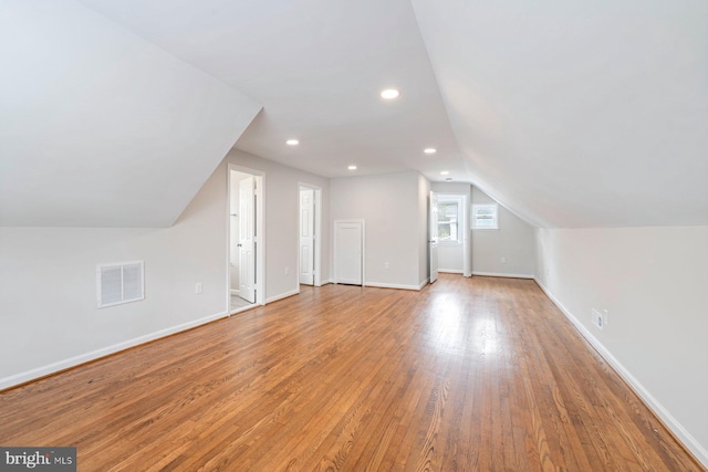 bonus room featuring light wood-type flooring and vaulted ceiling