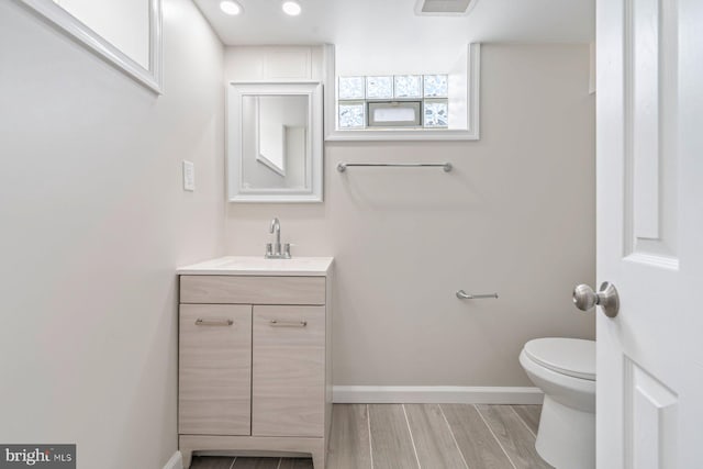 bathroom featuring hardwood / wood-style flooring, vanity, and toilet