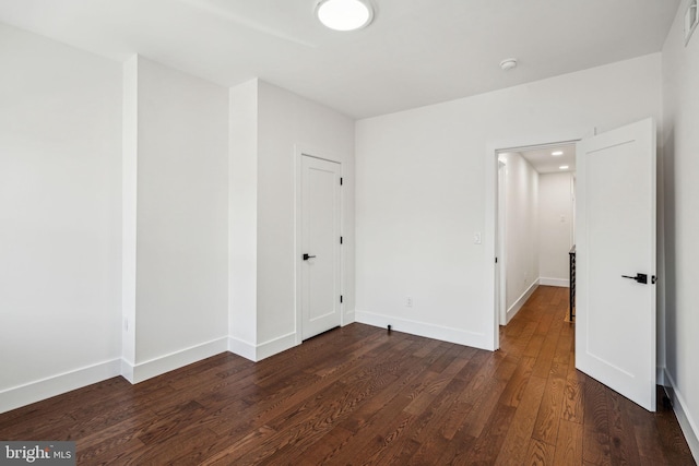 spare room featuring dark wood-type flooring