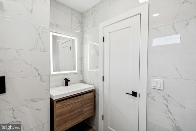 bathroom with vanity and tile walls