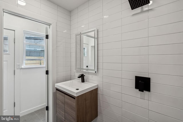 bathroom with tile patterned flooring, vanity, and tile walls