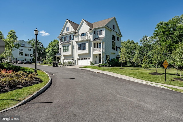 view of front of property with a balcony, a garage, and a front lawn