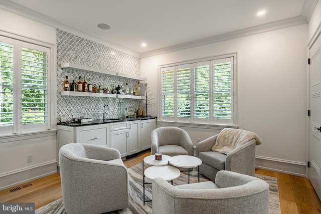 bar featuring a wealth of natural light, white cabinetry, and light hardwood / wood-style flooring