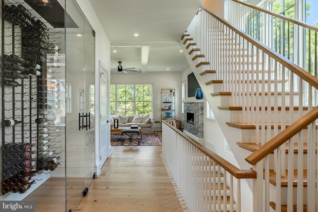 interior space featuring beam ceiling, ceiling fan, and light hardwood / wood-style flooring