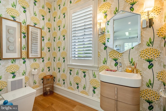 bathroom with toilet, vanity, and hardwood / wood-style flooring