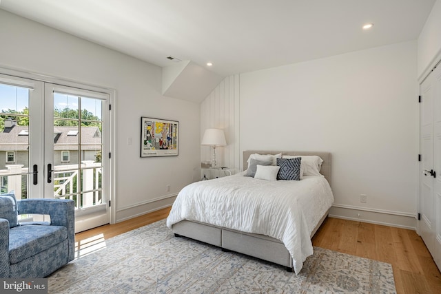 bedroom featuring hardwood / wood-style flooring, access to exterior, lofted ceiling, and french doors