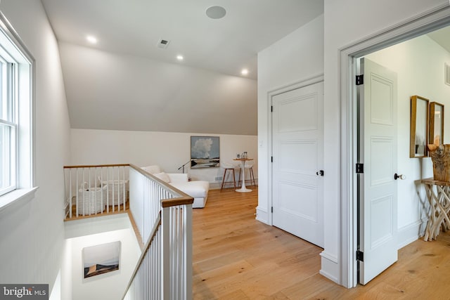 hallway with light hardwood / wood-style floors and lofted ceiling